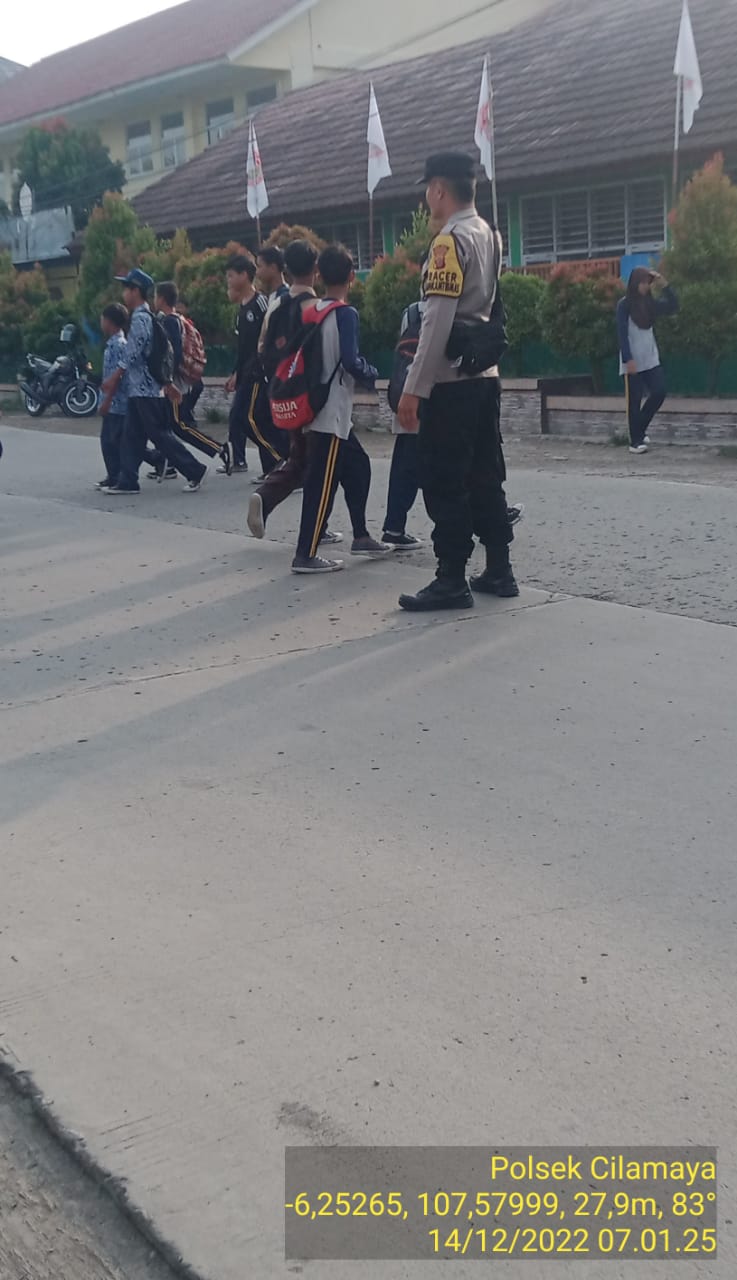 Anggota Polsek Cilamaya Polres Karawang Atur Lalu Lintas Dan Bantu Siswa dan siswi SMPN 1 Cilamaya Menyeberang Jalan
