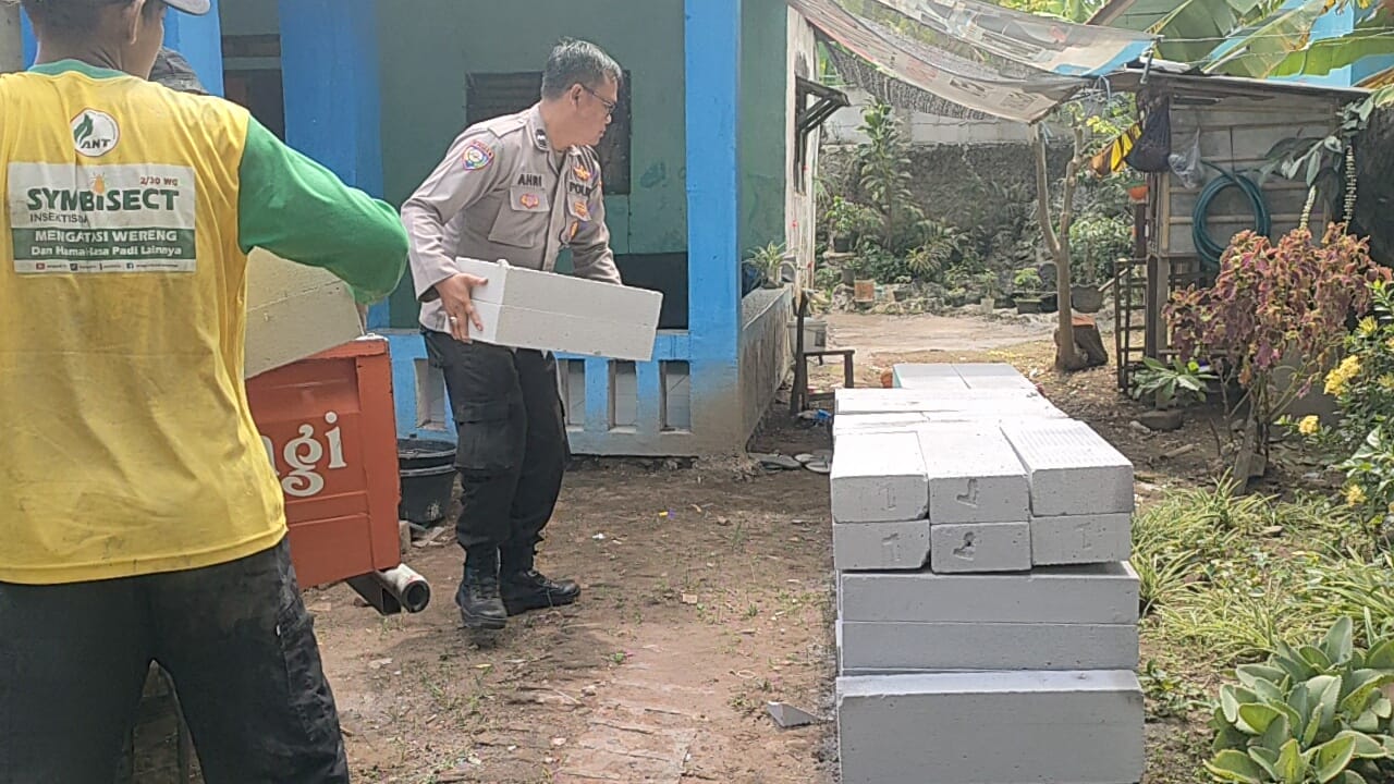 Aipda M. AHRI Bhabinkamtibmas Desa Tanjungjaya Polsek Tempuran Polres Karawang Bantu Menurunkan Bata Hebel