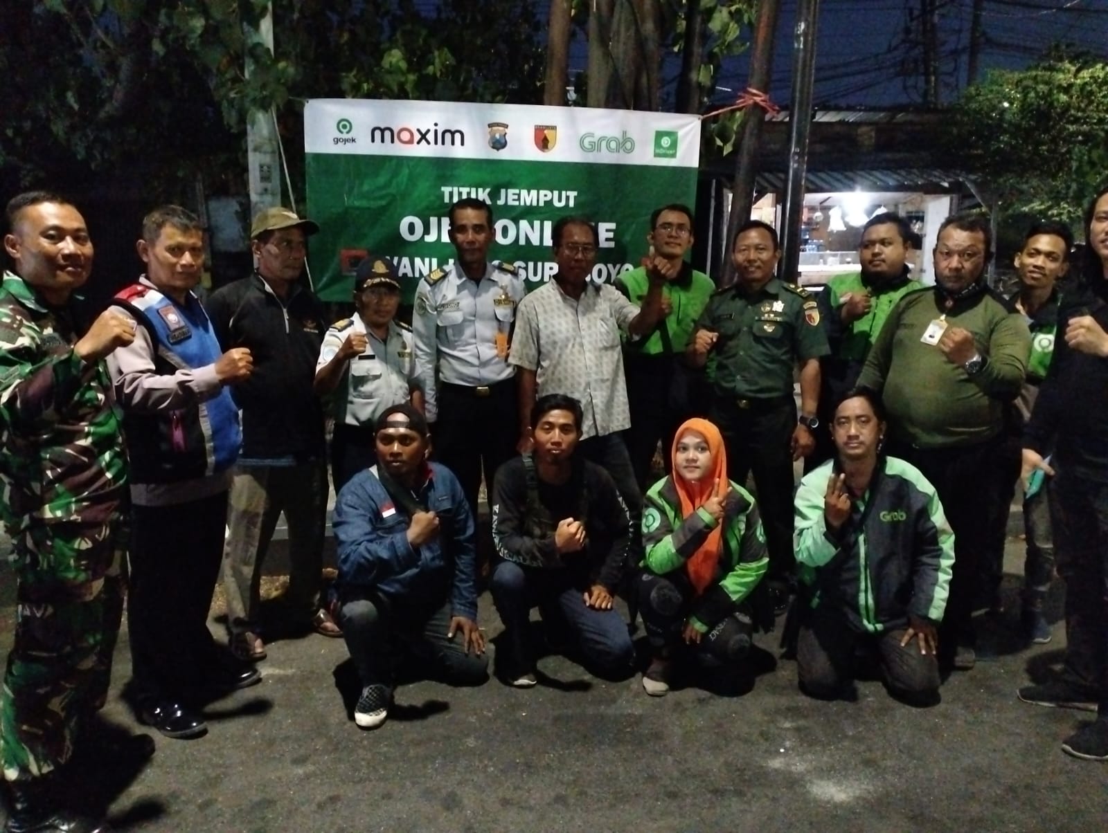 Babinsa Tambak Osowilangun Monitoring Kegiatan Pemasangan Banner Batas Titik Penjemputan Ojek Online
