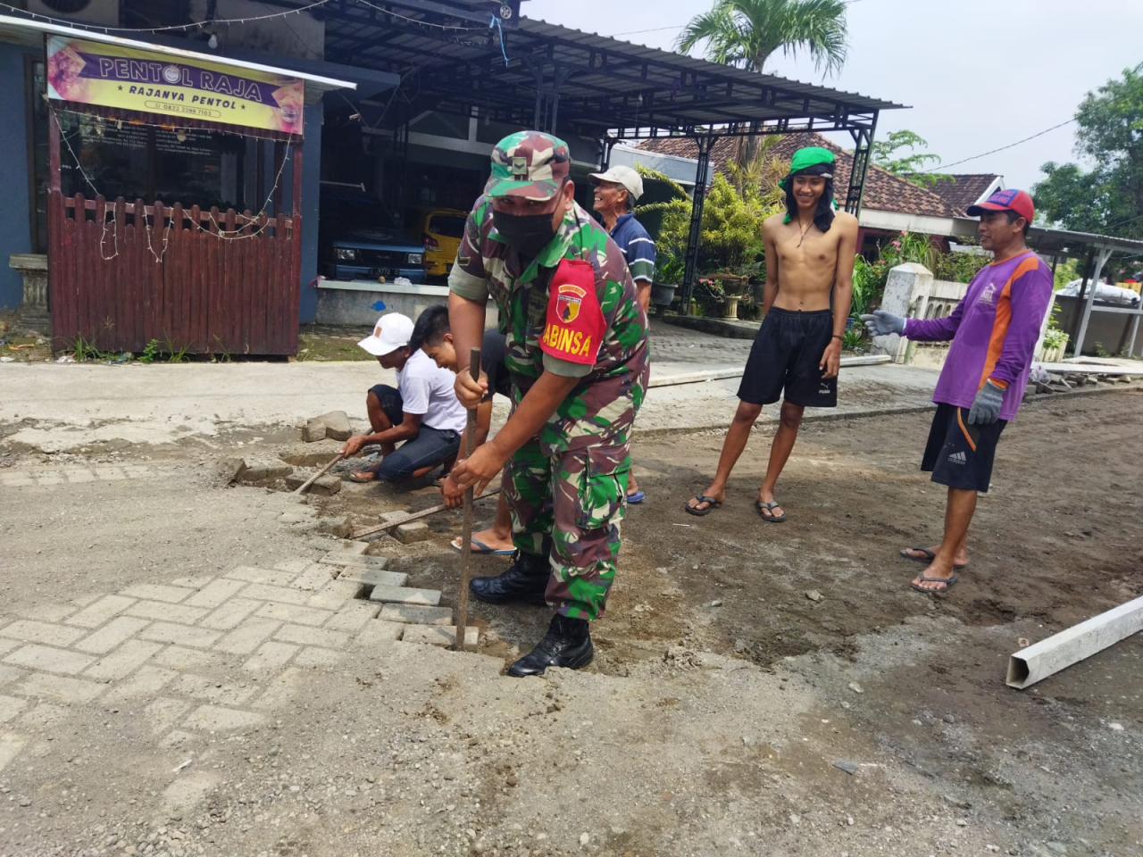 Bantu Pemasangan Paving Blok, Babinsa Wringinanom Tumbuhkan Semangat Gotong-Royong Warga