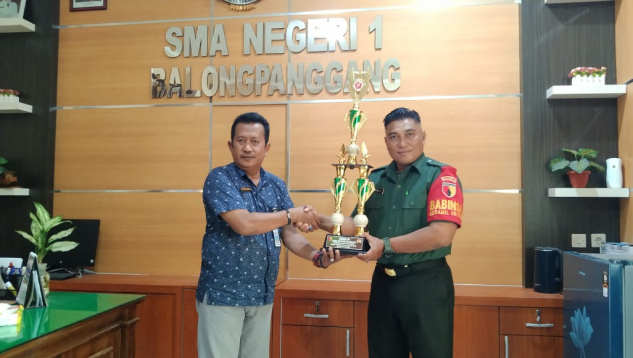 Babinsa Koramil Balongpanggang Serahkan Piala Kepada SMAN 1 Balongpanggang Pemenang Lomba PBB