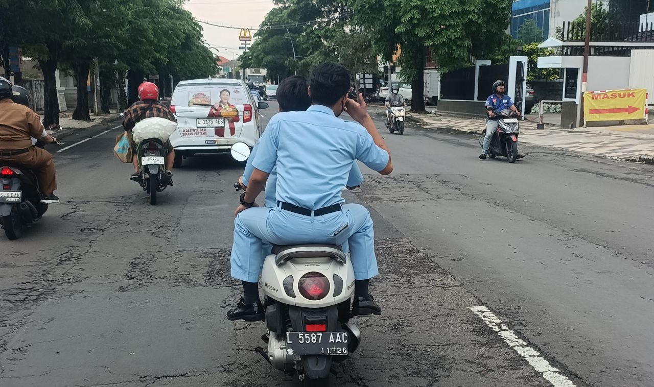 Dua Pria Berseragam Biru Muda Terpantau Berboncengan Tanpa Helm di Margorejo Indah